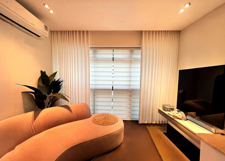 Floor-to-ceiling sheer white curtains in a modern living room.