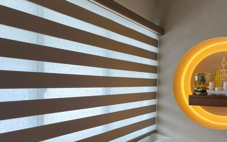 Striped zebra blinds in a room with warm circular lighting.