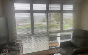 Venetian blinds installed on a window following a measurement guide.