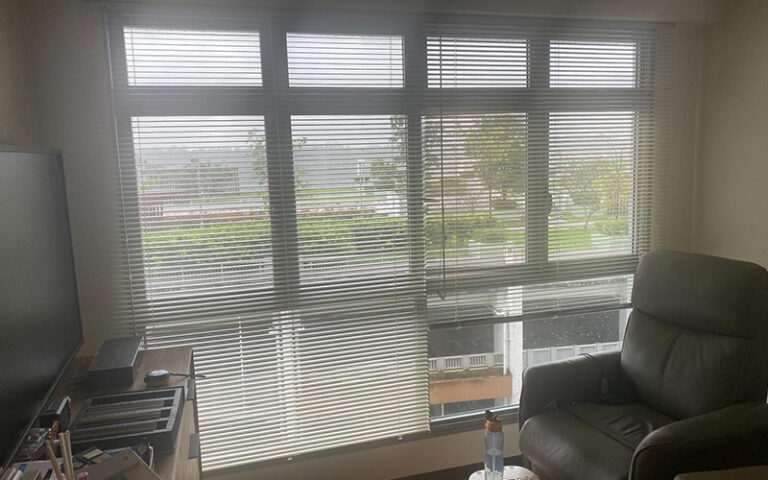 Venetian blinds installed on a window following a measurement guide.
