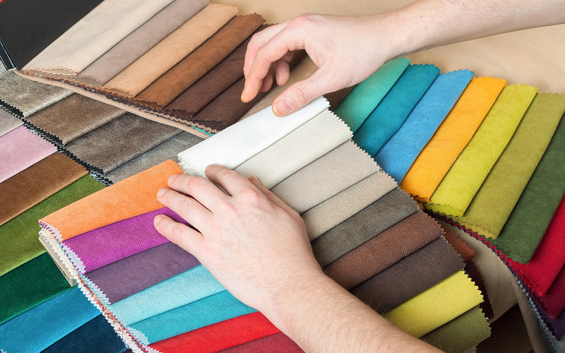 Designer browsing colorful fabric swatches for living room curtains.