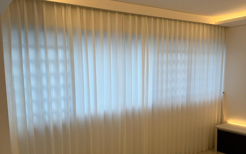 Soft white ripple fold curtains providing living room privacy.