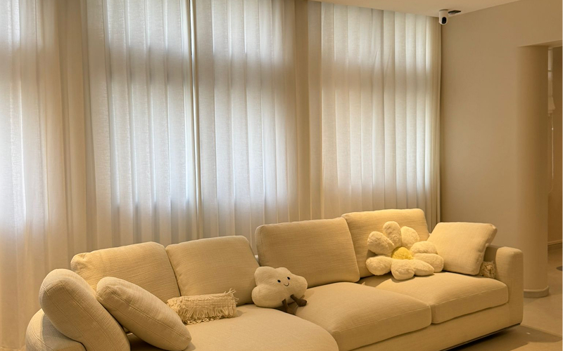 Elegant cream-colored curtains complementing a cozy, neutral living room.