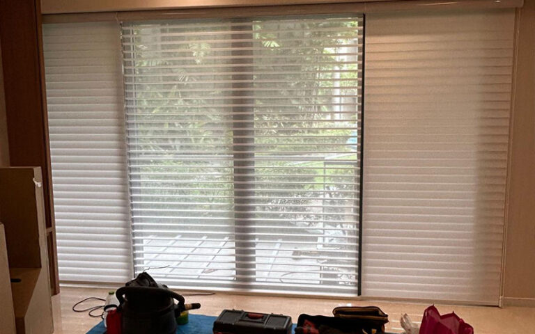 A set of modern, light-filtering Venetian blinds installed on a large window