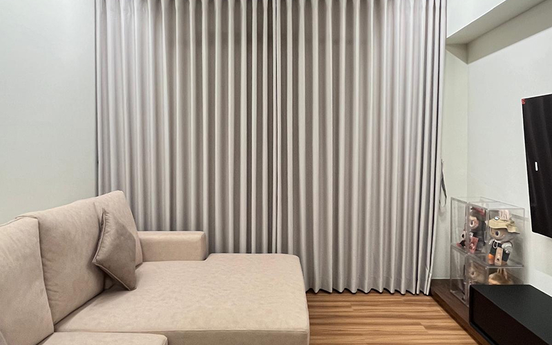 Modern neutral pleated curtains in a living room setting.