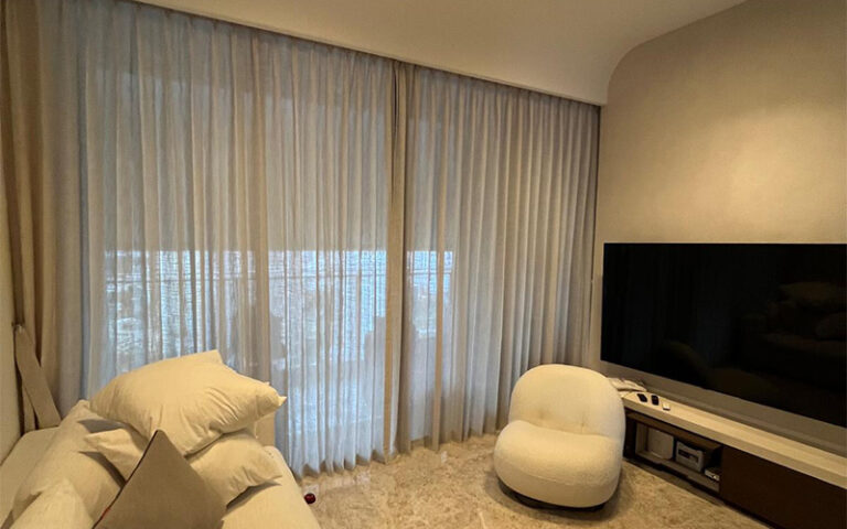 Sheer white curtains diffused light in a modern living room.