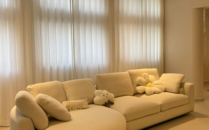 Long sheer white curtains installed in a modern living room.