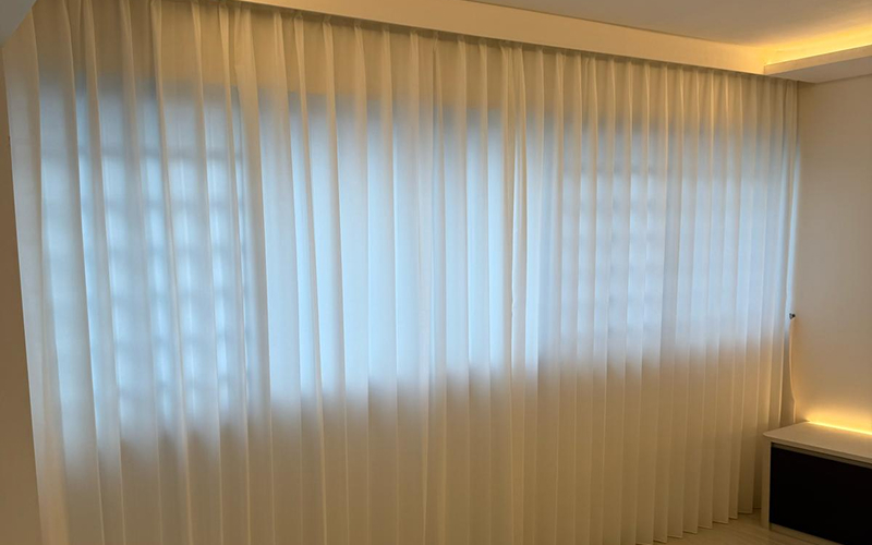 White ripple fold sheer curtains in a modern condo bedroom.