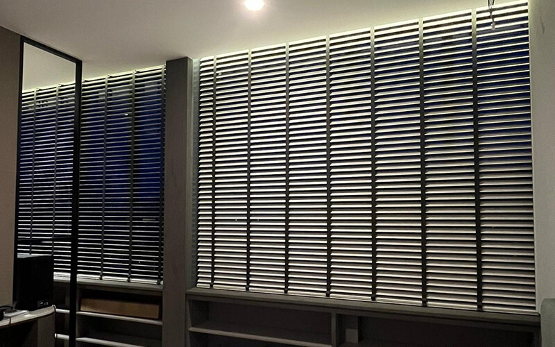 Modern grey venetian blinds installed in a sleek home office.